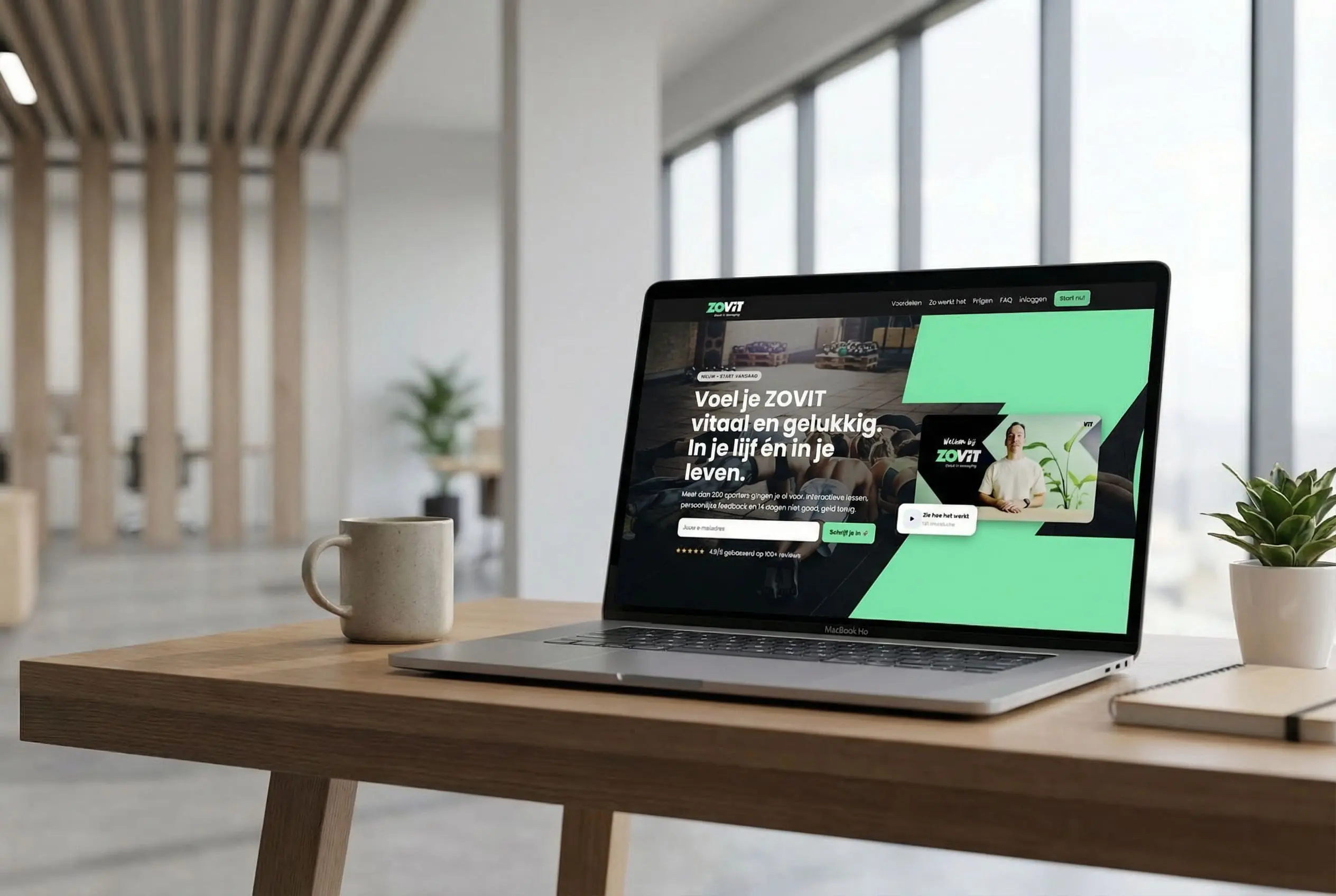 Laptop met website op het scherm op een houten bureau in een lichte kantoorruimte met koffiemok en plant.