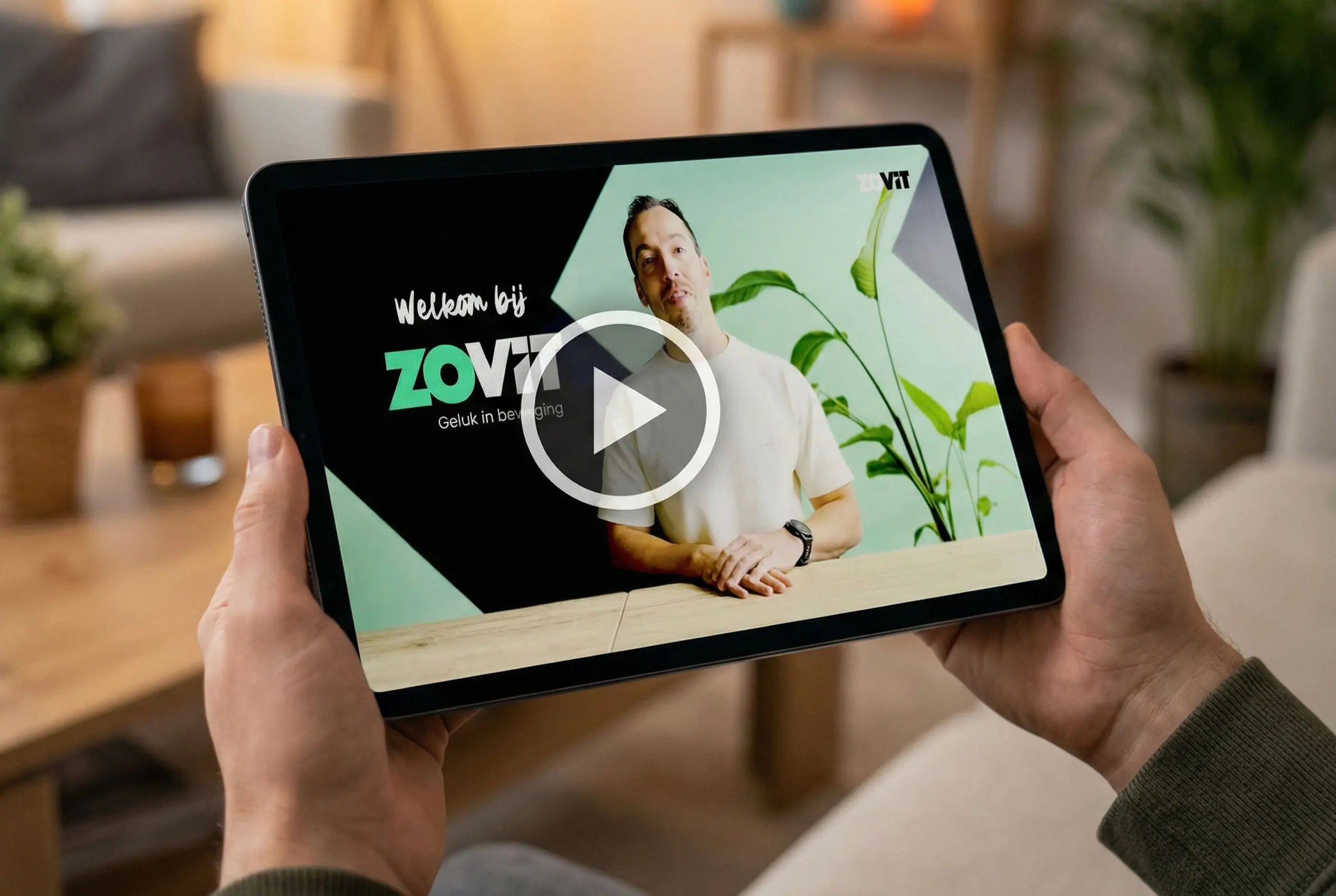 Persoon houdt een tablet vast waarop een Zovit uitleg video wordt afgespeeld.