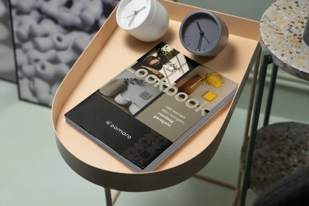 Domoro lookbook op zachtgekleurde bijzettafel met minimalistische klokjes.