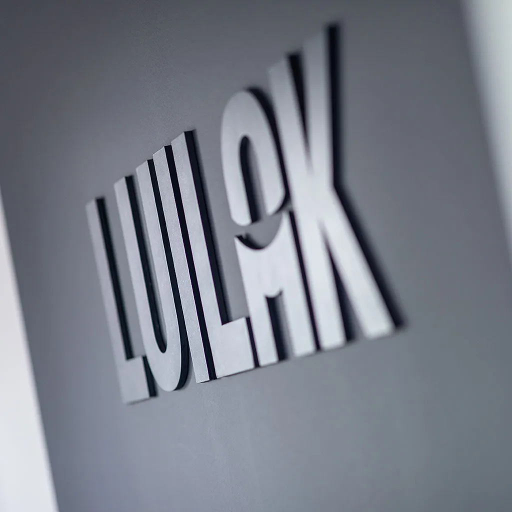 Close-up van het Luikat logo als driedimensionale letters op een muur.