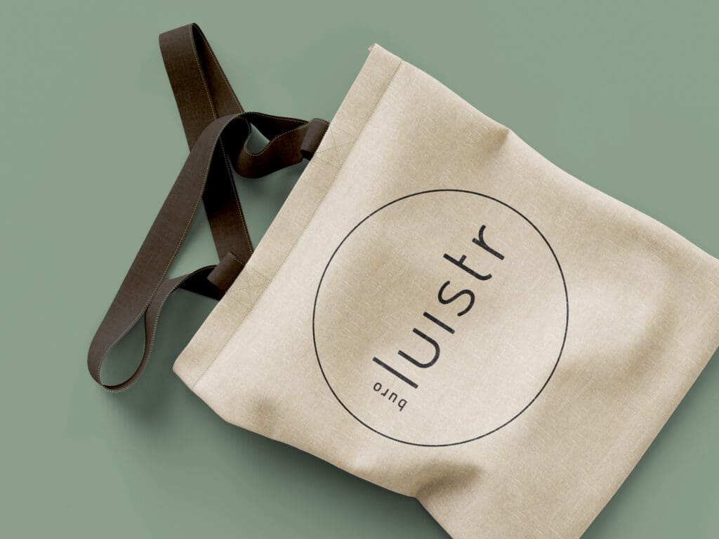 Stoffen tas van Buro Luistr met logo en donkere hengsels.