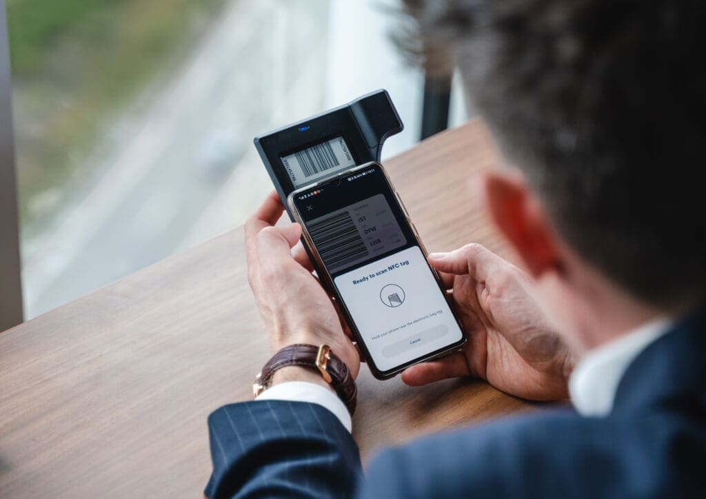 Man gebruikt smartphone om een Bagtag met barcode te scannen.