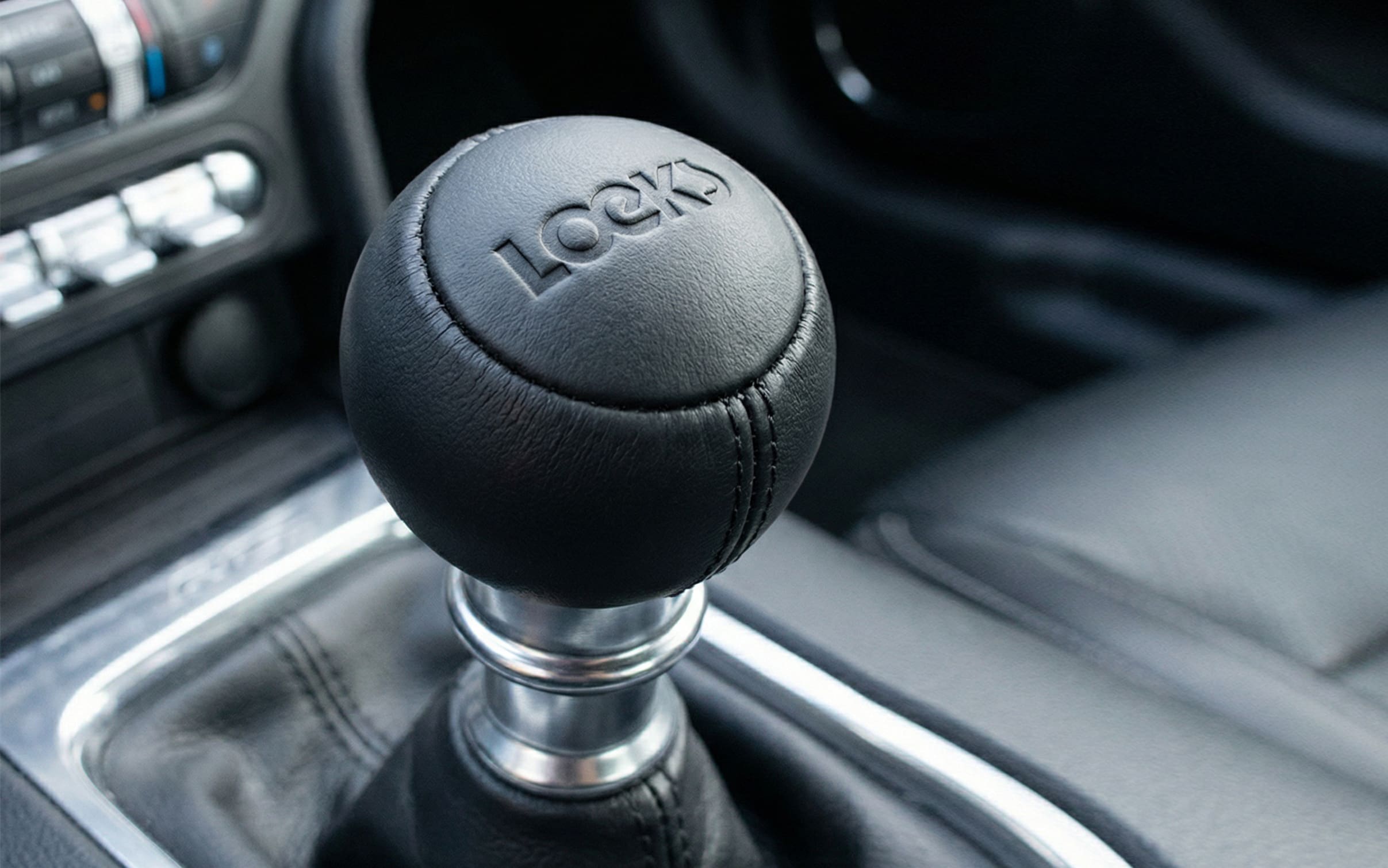 Close-up van zwarte versnellingspook met tekst “LOEKS” in auto-interieur, marketingstrategie. 