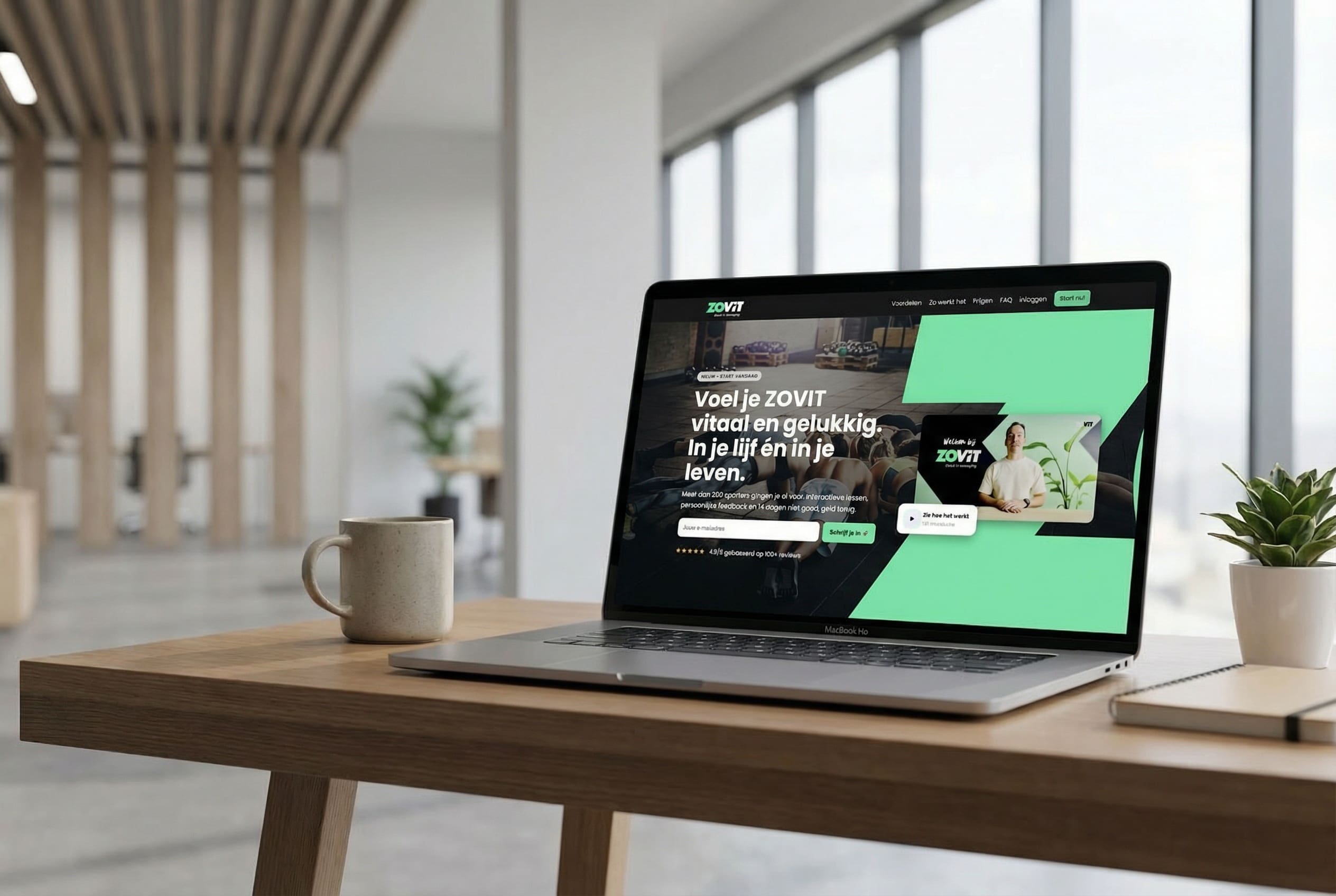 Laptop met website op het scherm op een houten bureau in een lichte kantoorruimte met koffiemok en plant.