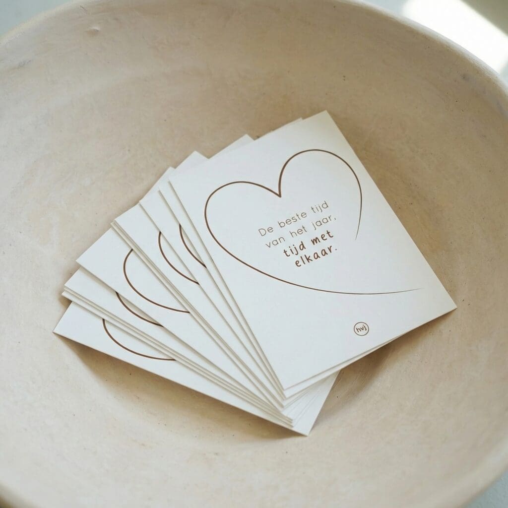 Kleine kaartjes met lijntekening van een hart liggen gestapeld in een beige schaal.