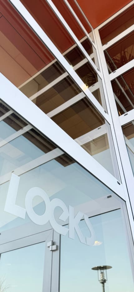 Glazen gevel van het Loeks kantoor met het Loeks-logo zichtbaar op het raam van het gebouw.